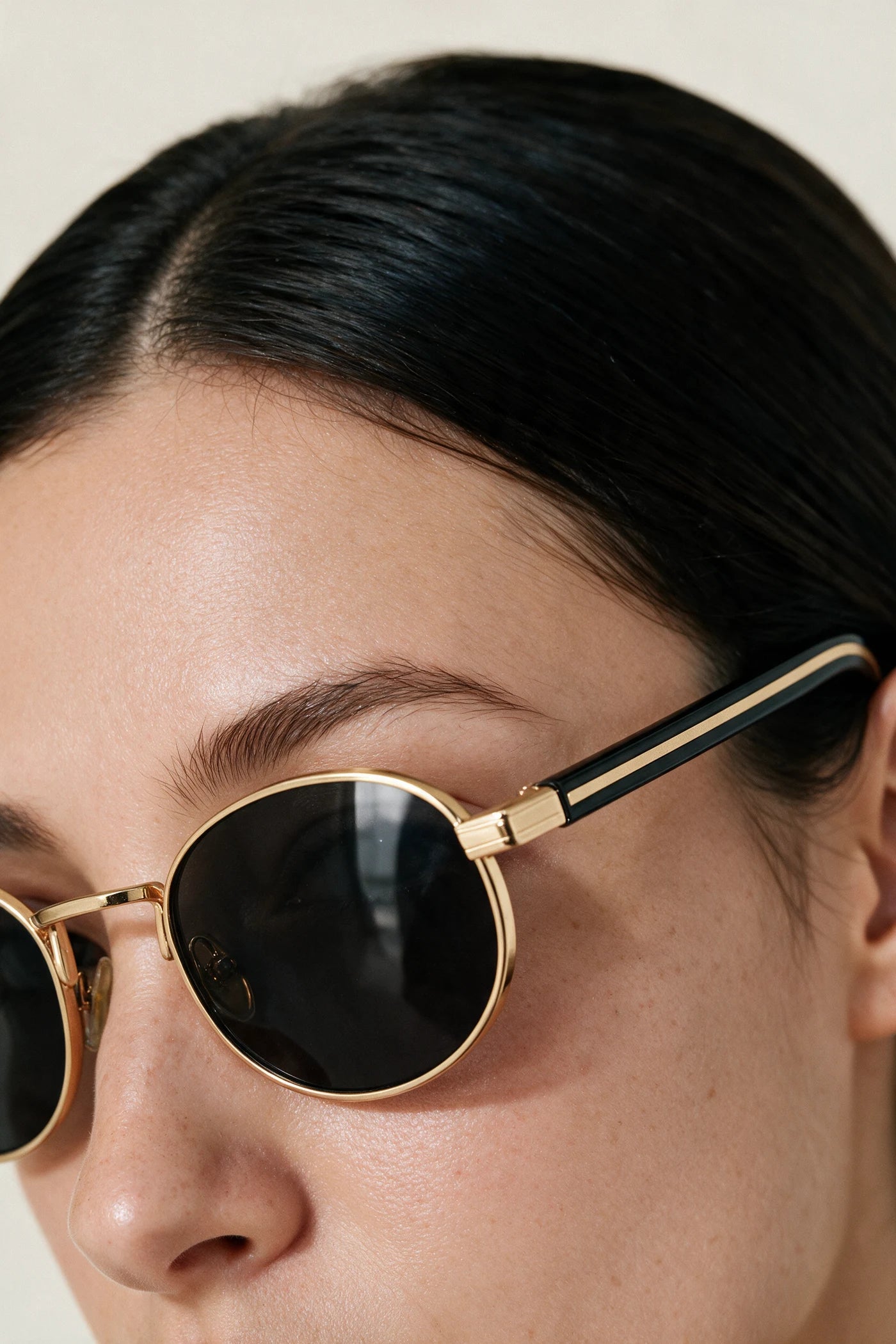 Close detail of the MARA gold rim, black temple with gold inlay and smoke lens