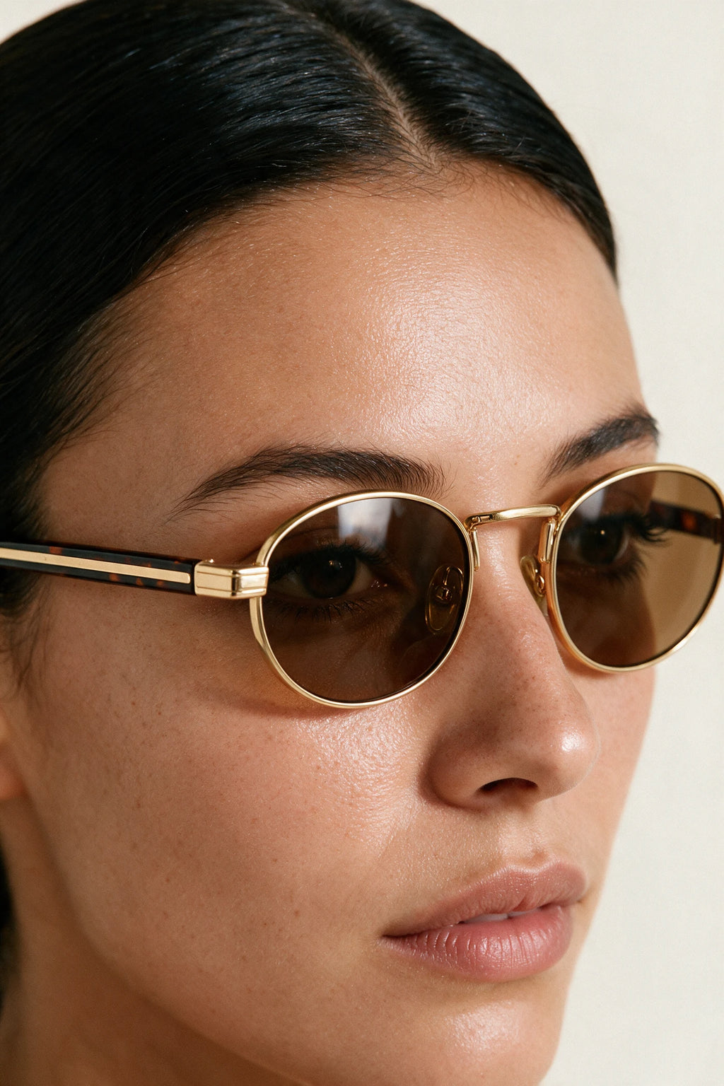 Close detail of the MARA gold rim, tortoiseshell temple with gold inlay and tea-tinted lens