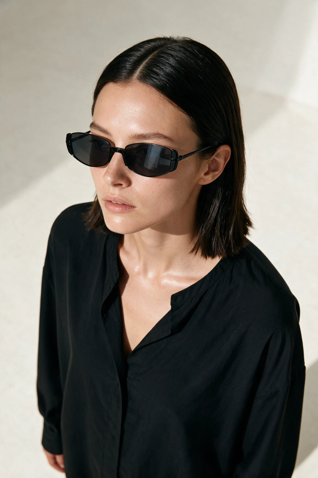 Woman wearing NEVA sunglasses in black with smoke lenses