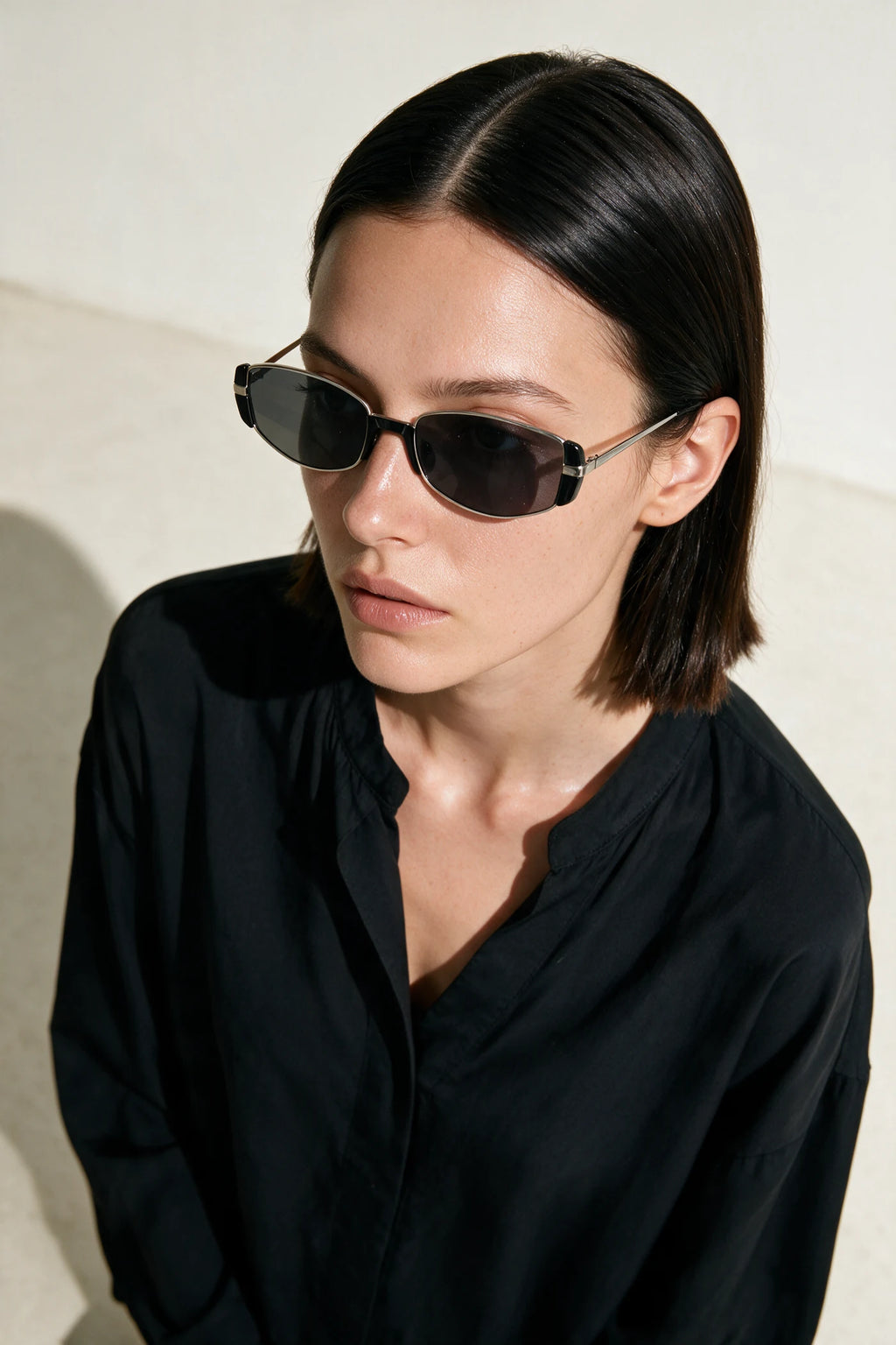 Woman wearing NEVA sunglasses in silver with smoke-grey lenses