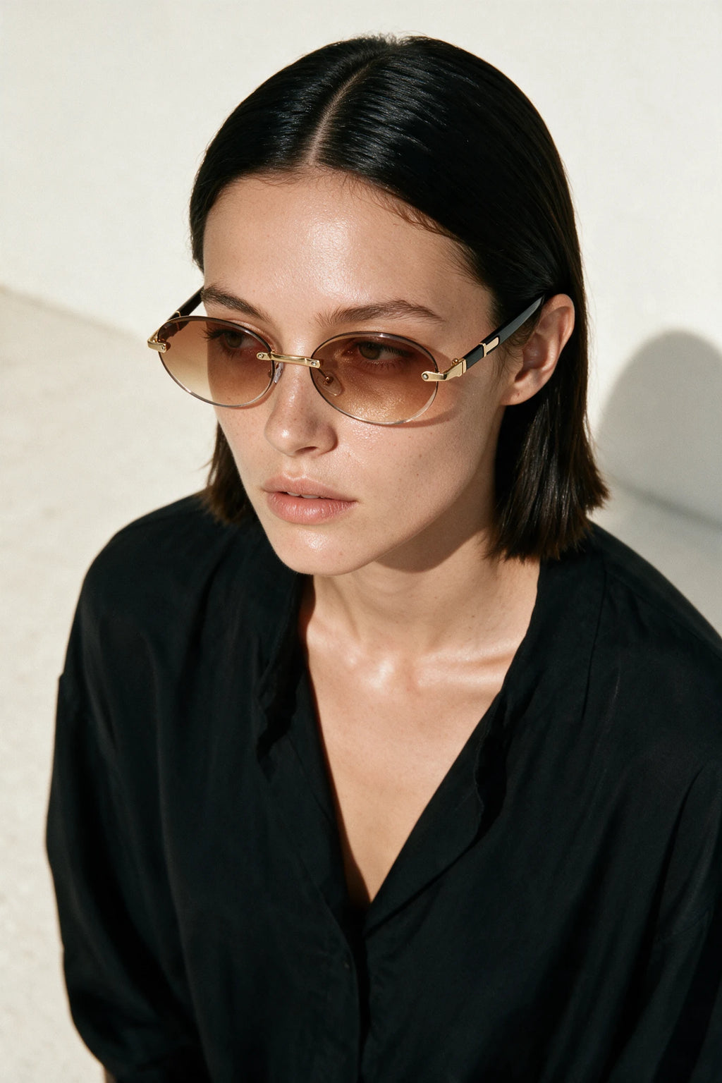Woman wearing SERA rimless oval sunglasses with gradient tea lenses